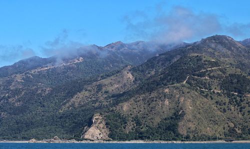 Scenic view of sea and mountains against sky