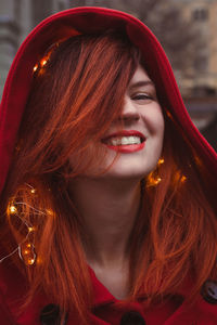Close up joyful young woman with glowing lights in hood portrait picture