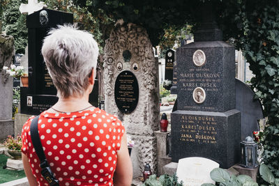 Rear view of woman standing on cemetery