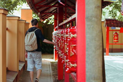 Rear view of man standing in temple outside building