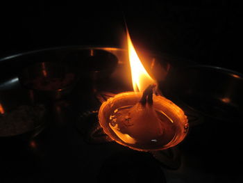 Close-up of lit candle in dark room