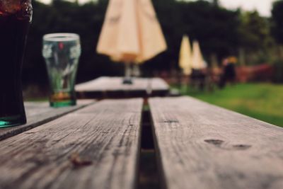 Drinking glasses on wooden table at field