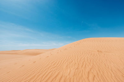 Scenic view of desert against blue sky