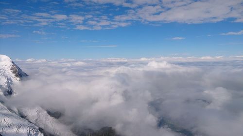 Aerial view of clouds over landscape against blue sky