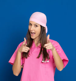 Portrait of beautiful young woman standing against pink blue sky