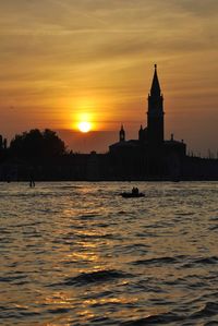 Silhouette of building against sky during sunset