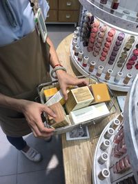 Low section of woman with beauty products on table in store