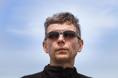 Portrait of senior man wearing sunglasses against sky