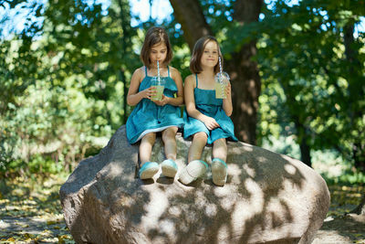 Two little girls drinking lemonade in park