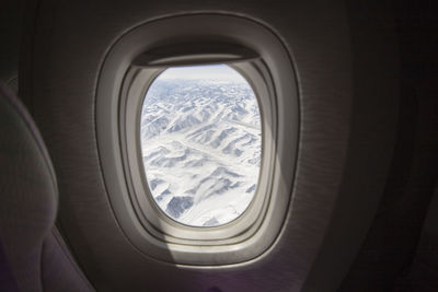 Snowcapped mountains seen through airplane window