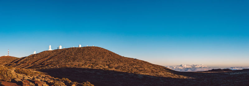 Scenic view of land against clear blue sky