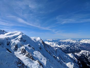 Scenic view of snowcapped mountains against blue sky