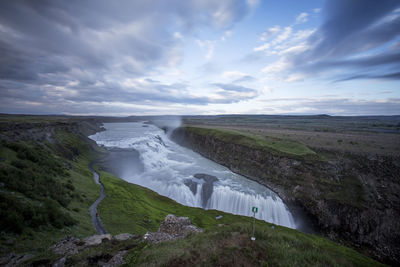 Scenic view of waterfall against sky