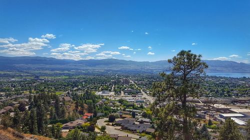 High angle view of houses and trees in town against sky