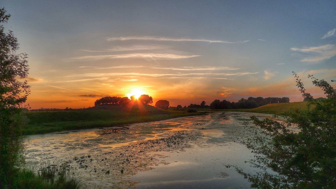 sunset, sun, water, scenics, tranquil scene, sky, orange color, tranquility, beauty in nature, sunlight, nature, idyllic, reflection, tree, cloud - sky, silhouette, river, landscape, sunbeam, outdoors