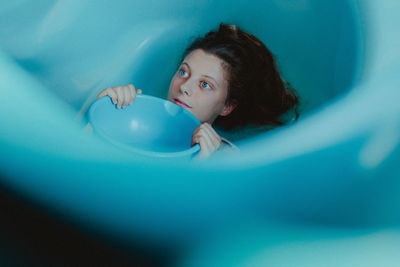 High angle portrait of young woman lying down in bathroom