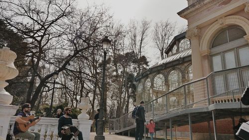 Low angle view of people on building against sky