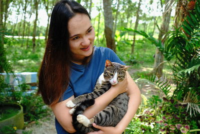 Portrait of smiling young woman holding cat