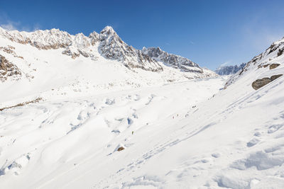 Scenic view of snowcapped mountains against clear blue sky