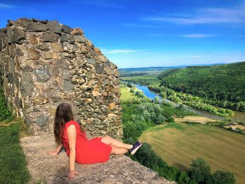 Woman on the top of a building looking down on idyllic landscape