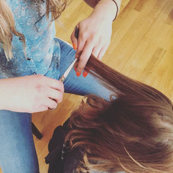 High angle view of hairdresser cutting hair of girl at salon