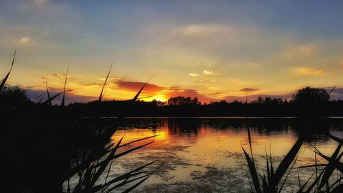 Scenic view of lake against orange sky