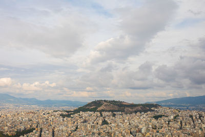 Aerial view of town by mountains against sky