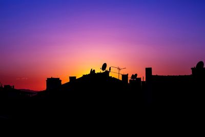 Silhouette buildings against blue sky during sunset