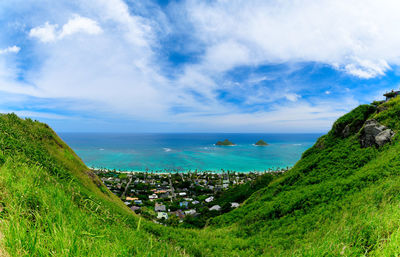 Scenic view of sea by townscape against sky