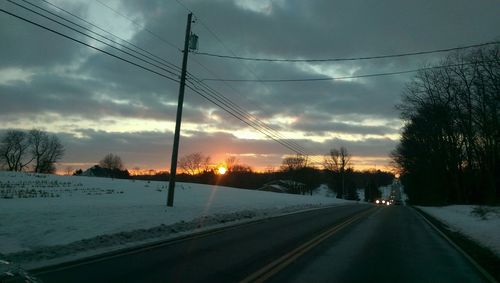 Snow covered road at sunset