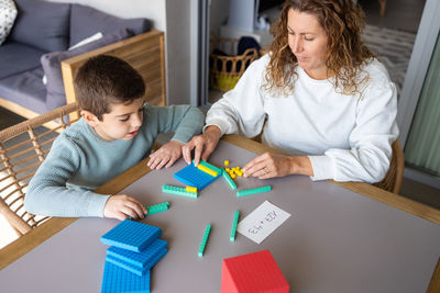 Mother teaching her son math with base 10 method at home