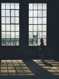 Side view of silhouette woman  against window in building
