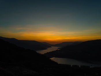 Scenic view of silhouette mountains against sky at sunset