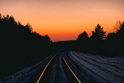 View of railroad tracks against sky during sunset