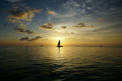 Boat sailing in sea at sunset