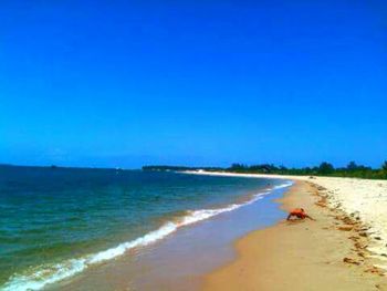 Scenic view of beach against clear blue sky