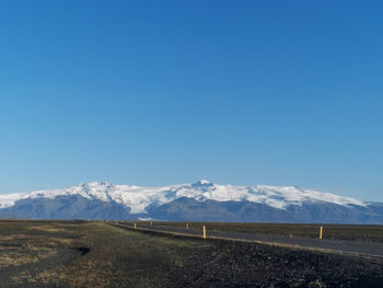 Scenic view of snowcapped mountains against blue sky