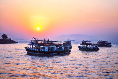 Boat sailing on sea against sky during sunset