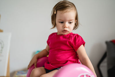 Portrait of cute girl sitting on bed at home