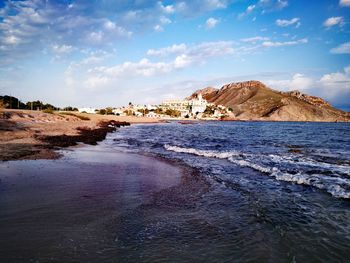 Scenic view of beach against cloudy sky