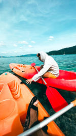 Woman on boat in sea against sky