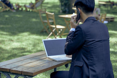 Midsection of man using mobile phone