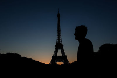 Silhouette man against eiffel tower during sunset