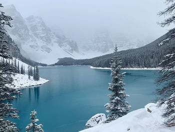 Scenic view of lake by snowcapped mountains during winter