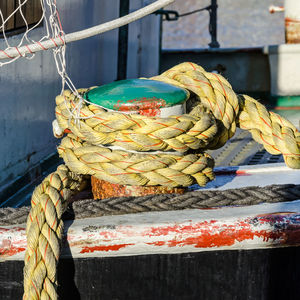 Close-up of rope tied to fishing net at harbor