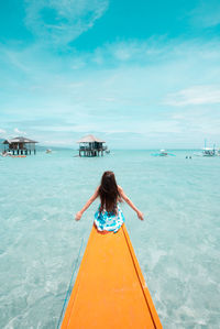 Rear view of woman sitting in boat on sea