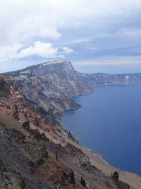 Scenic view of sea and mountains against sky