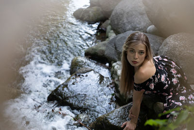 Portrait of young woman standing on rock