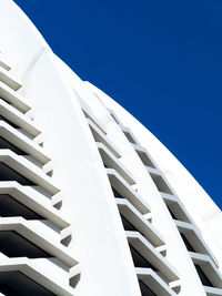 Low angle view of modern building against clear blue sky