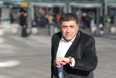 Portrait of a young man with cars on road